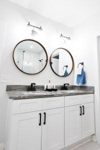 a bathroom with two mirrors above a white sink at Elmwood Park Retreat Renovated 3 Bed 2 Bath DT in Columbia +65 photos