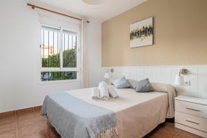 ein Schlafzimmer mit einem Bett mit zwei Handtüchern darauf in der Unterkunft Jardín del Golf apartamento con jardín privado in Chiclana de la Frontera + 18 Fotos