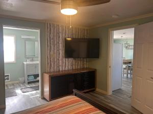 a living room with a flat screen tv on the wall at Surfside 13 - Cute Lakefront Condo! in Oscoda