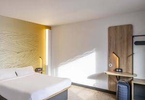a bedroom with a white bed and a yellow wall at B&B HOTEL Bordeaux Bassins à flot in Bordeaux