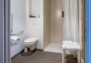 a white bathroom with a toilet and a shower at B&B HOTEL Bordeaux Bassins à flot in Bordeaux