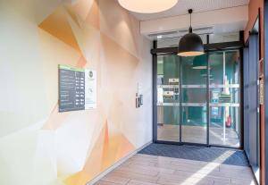 an entrance to a building with a colorful wall at B&B HOTEL Bordeaux Bassins à flot in Bordeaux