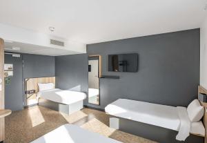 a hospital room with two beds and a tv at B&B HOTEL Bordeaux Bassins à flot in Bordeaux