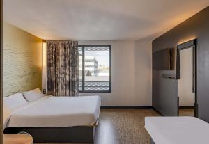 a hotel room with a bed and a window at B&B HOTEL Bordeaux Bassins à flot in Bordeaux