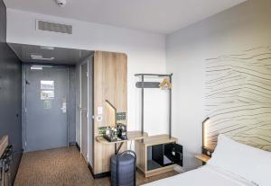 a hotel room with a bed and a desk at B&B HOTEL Bordeaux Bassins à flot in Bordeaux