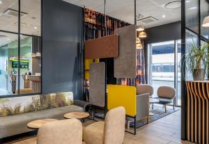 a lobby with a couch and chairs and tables at B&B HOTEL Bordeaux Bassins à flot in Bordeaux