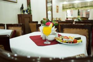 un tavolo con un piatto di cibo e un bicchiere di succo di Sirkeci Emek Hotel a Istanbul