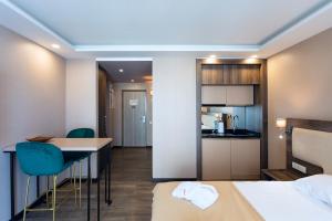 Habitación de hotel con cocina, cama y habitación en SUNRISE APART-HOTEL, en Batumi