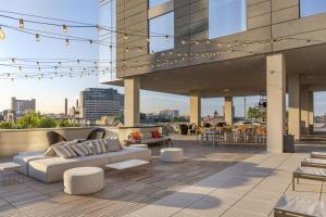 a rooftop patio with a couch and tables and chairs at Omni Louisville Hotel in Louisville
