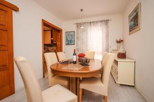 Un comedor con una mesa de madera y sillas blancas. en Great location,2 bedroom apartment, en Cavtat