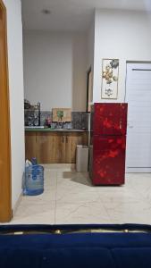 a kitchen with a red refrigerator in a room at Serenity Inn in Islamabad