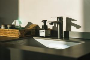 encimera con lavabo y espejo en 张家界大峡谷迴音森林乡村民宿, en Cili