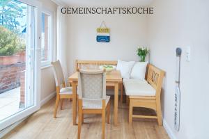 Un comedor con mesa y sillas en Villa Dünenblick Doppelzimmer Bernstein, en Timmendorfer Strand