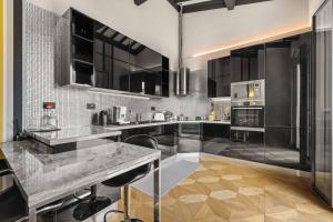 eine Küche mit schwarzen Schränken und einer Marmoroberfläche in der Unterkunft Nato Felice Apartment in Florenz