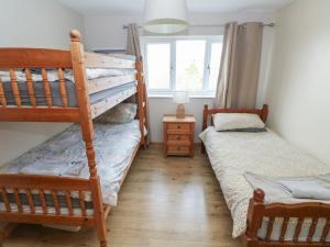 a bedroom with two bunk beds and a window at Carreg Yr Onnen in Haverfordwest