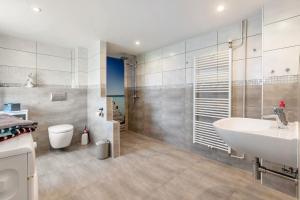 a bathroom with a sink and a toilet and a shower at Ferienhaus Angela in Neuenkirchen +14 photos