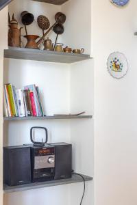 a microwave sitting on a shelf with books at Quiet and Cozy home with Wi-Fi CASA PREARINO in Vernazza