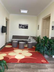 a living room with a couch and a red rug at Hostel Rayska Yabalka in Varna City