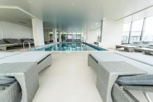 a swimming pool with two chairs and a swimming pool at Alezi Apartamente in Mamaia Sat/Năvodari +61 photos