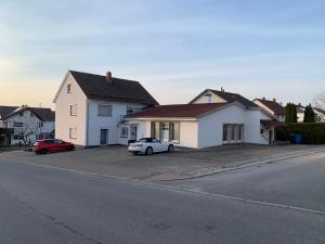 a white house with two cars parked in a driveway at Modern Living - Im Grund in Spaichingen