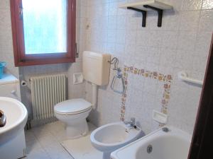 a bathroom with a white toilet and a sink at Appartamento Aquileia in Lido +23 photos