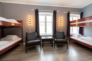 a room with two bunk beds and a desk and chairs at Pensjonat Jarlen in Trondheim