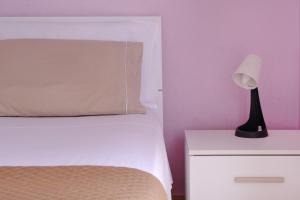 a bed with a black lamp on a night stand at Andrea's House in Locri