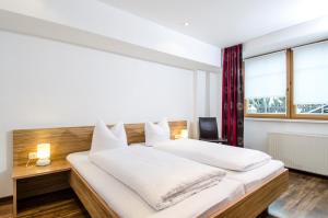 a bedroom with a large white bed and a window at Ambiente Appartements in Ischgl