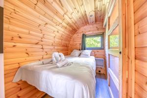 Un dormitorio con una cama en una cabaña de troncos en Otonneauxstress - Vigneron, en Saint-Vivien-de-Médoc