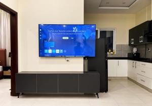 a large flat screen tv on a wall in a kitchen at Zen Haven by StayMehman in Rawalpindi