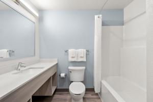 a bathroom with a toilet and a sink and a shower at WoodSpring Suites Chandler Phoenix Medical Center in Chandler +24 photos