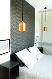 a bedroom with a bed and two pendant lights at Villa Bel-Amy in Saint-Pair-sur-Mer