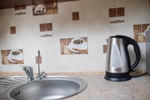 a tea kettle sitting on a counter next to a sink at Lions Heart Hostel in Lviv