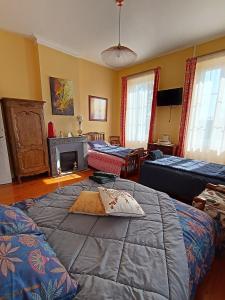 ein Wohnzimmer mit einem Bett und einem Kamin in der Unterkunft Gîte La Burthe in Monprimblanc