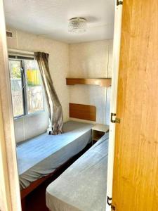 a bedroom with two beds and a window at Your Camp Kormoran Domek Holender in Hel