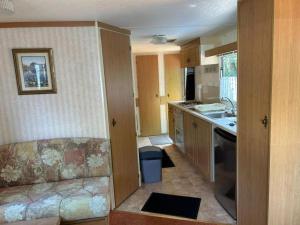 a small kitchen with a couch and a sink at Your Camp Kormoran Domek Holender in Hel