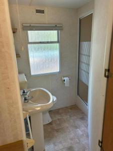 a bathroom with a sink and a window at Your Camp Kormoran Domek Holender in Hel