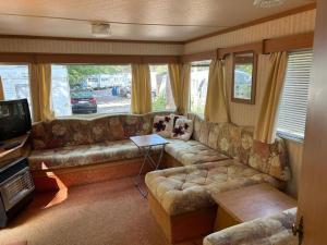 a living room with a couch and a television at Your Camp Kormoran Domek Holender in Hel