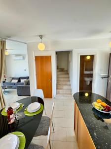 a kitchen and living room with a counter and a table at Villa ILIOS Cozy 2BR with Pool in Paralimni