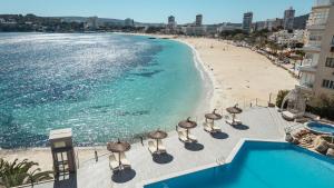 an aerial view of a beach with umbrellas and the ocean at Bahia Principe Escape Coral Playa Adults Only in Magaluf
