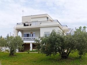 a white house with trees in front of it at Palataki in Epanomi
