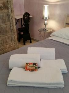 Una cama con toallas blancas y una caja. en Residenza Del Turista, en Catania