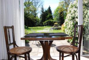 a wooden table and two chairs on a porch at Little Manor in Cheltenham