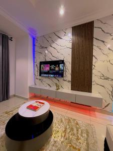 a living room with a tv and a table at 1 bedroom Shortlet Apt at Osapa London Lekki in Lagos