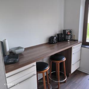 a kitchen with a counter with two stools at FeWo in Bleicherode +4 photos