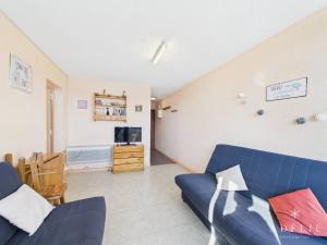 a living room with a blue couch and a television at Studio confortable au centre, proche remontées mécaniques - FR-1-398-573 in Montvalezan