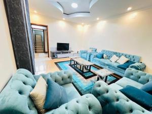 a living room with blue couches and a tv at VENUS APARTMENT Kigali in Kigali