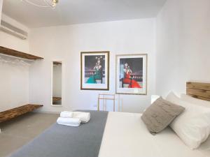 a bedroom with a white bed with three pictures on the wall at Symphony Sound Villa with Pool in Chiesanuova +242 photos