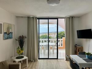 a living room with a view of a table at Panoramic Paradise Tenerife Ocean View & Comfort in Adeje