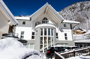 a large white building with a car parked in front of it at Ambiente Appartements in Ischgl